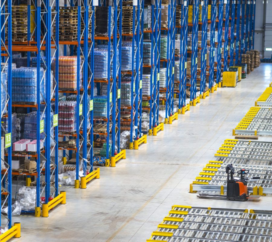 Distribution warehouse building interior and large storage area with goods on the shelf.